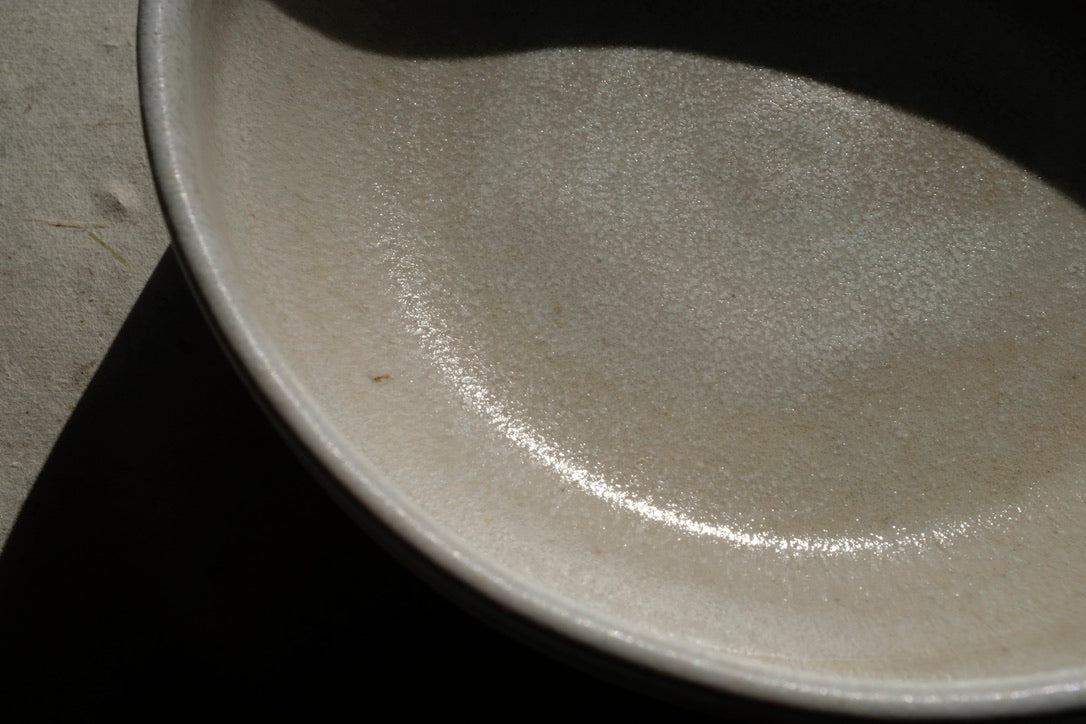 assiette ALPHA, petite assiette bi-colore : émail blanc et grès moucheté. Conçue pour l'usage quotidien ; salades, soupe, entrée, dessert ou tapas, l'assiette ALPHA se veut multiple. Dimensions : ∅. 16 x h. 5 cm. Email blanc effet