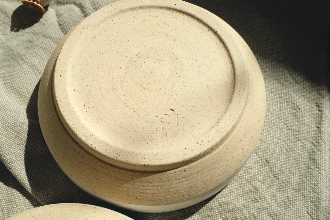 assiette ALPHA, petite assiette bi-colore : émail blanc et grès moucheté. Conçue pour l'usage quotidien ; salades, soupe, entrée, dessert ou tapas, l'assiette ALPHA se veut multiple. Dimensions : ∅. 16 x h. 5 cm