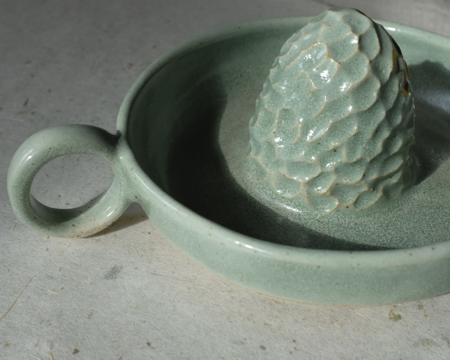 Presse agrumes JUDITH, idéal pour les citronnades ou les jus d'oranges matinaux. Bi-matière : vert d'eau et grès Belge moucheté. Entretien : Lave vaisselle. Dimensions : Dimensions : ∅. 12 x h. 4,5 cm