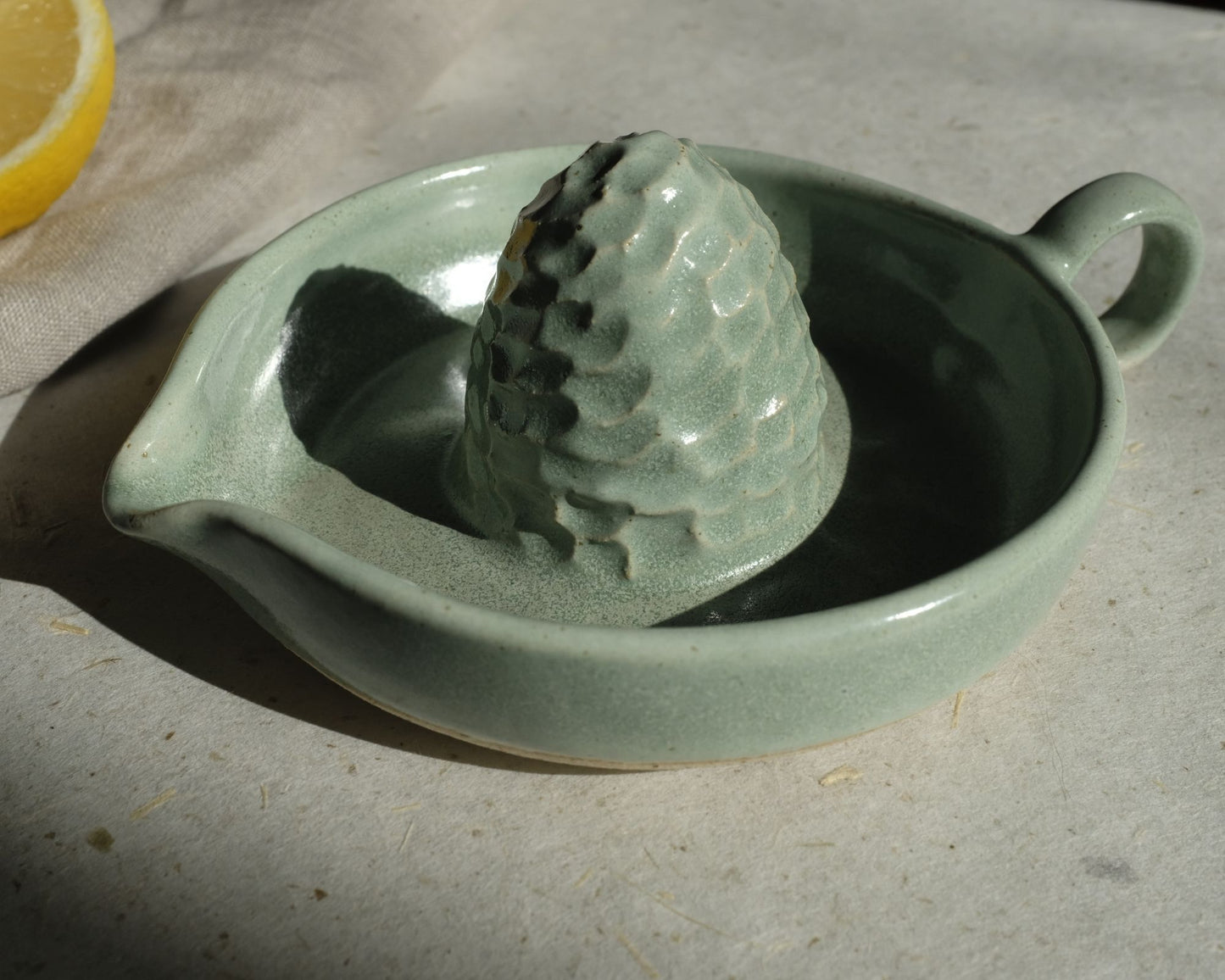 Presse agrumes JUDITH, idéal pour les citronnades ou les jus d'oranges matinaux. Bi-matière : vert d'eau et grès Belge moucheté. Entretien : Lave vaisselle. Dimensions : Dimensions : ∅. 12 x h. 4,5 cm