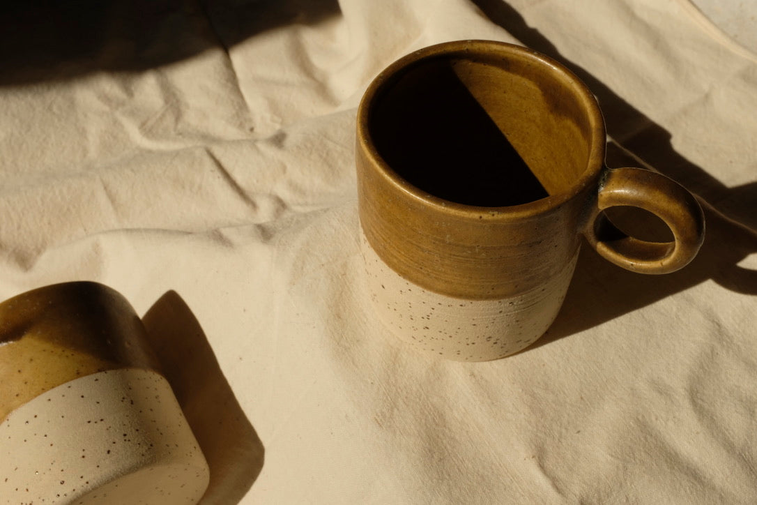 Tasse Aurore, pour le thé ou le café. Bi-matière : couleur cumin et grès belge moucheté. Entretien : lave vaisselle. Dimensions : ∅.7,3 x h.8,5 cm - 200 ml